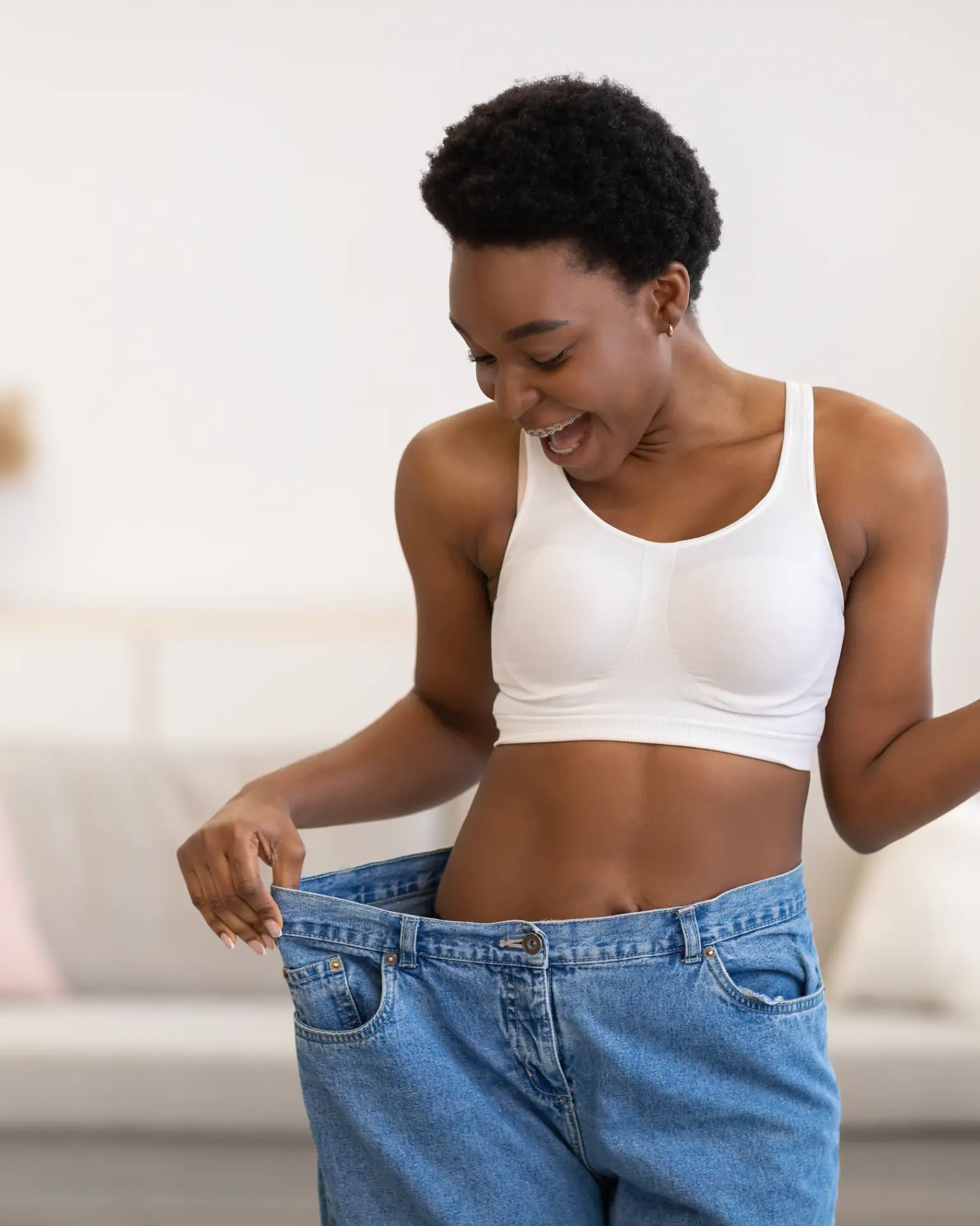 Client holding out a pair of jeans that no longer fit